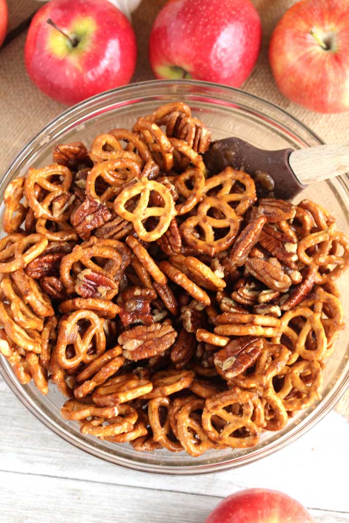 A bowl filled with pretzels and pecans.