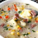 Pin image of creamy potato ham soup in a white bowl