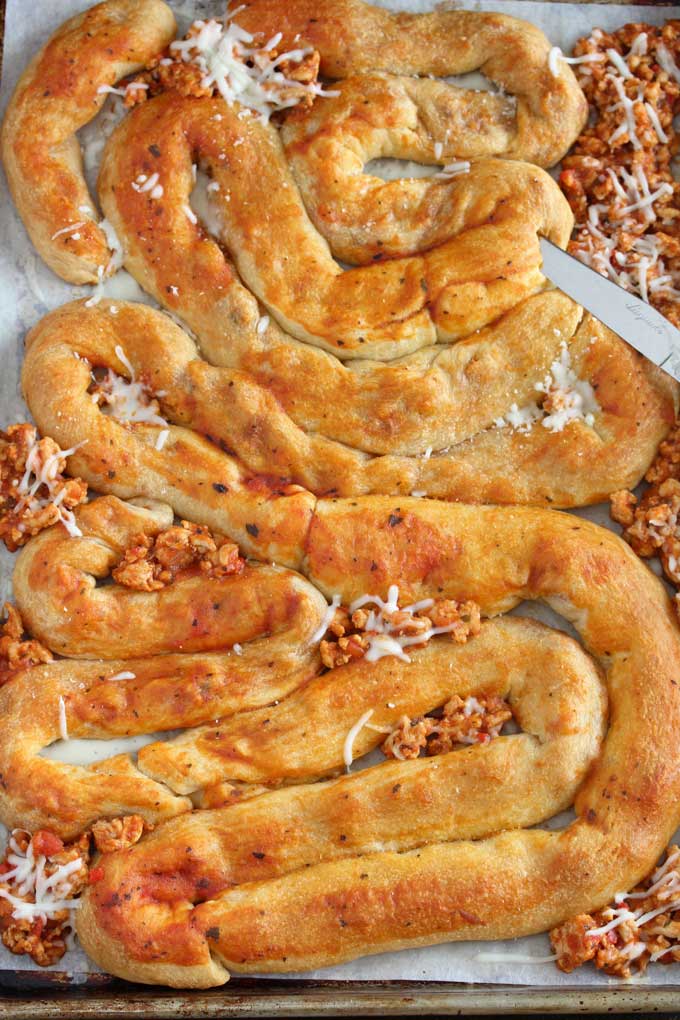 Stuffed Crescent Rolls shaped as intestines on a sheet pan.