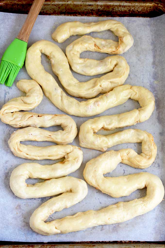Stuffed crescent rolls shaped like intestines on a sheet pan.