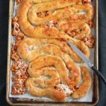 Stuffed Crescent Rolls shaped as intestines on a sheet pan.