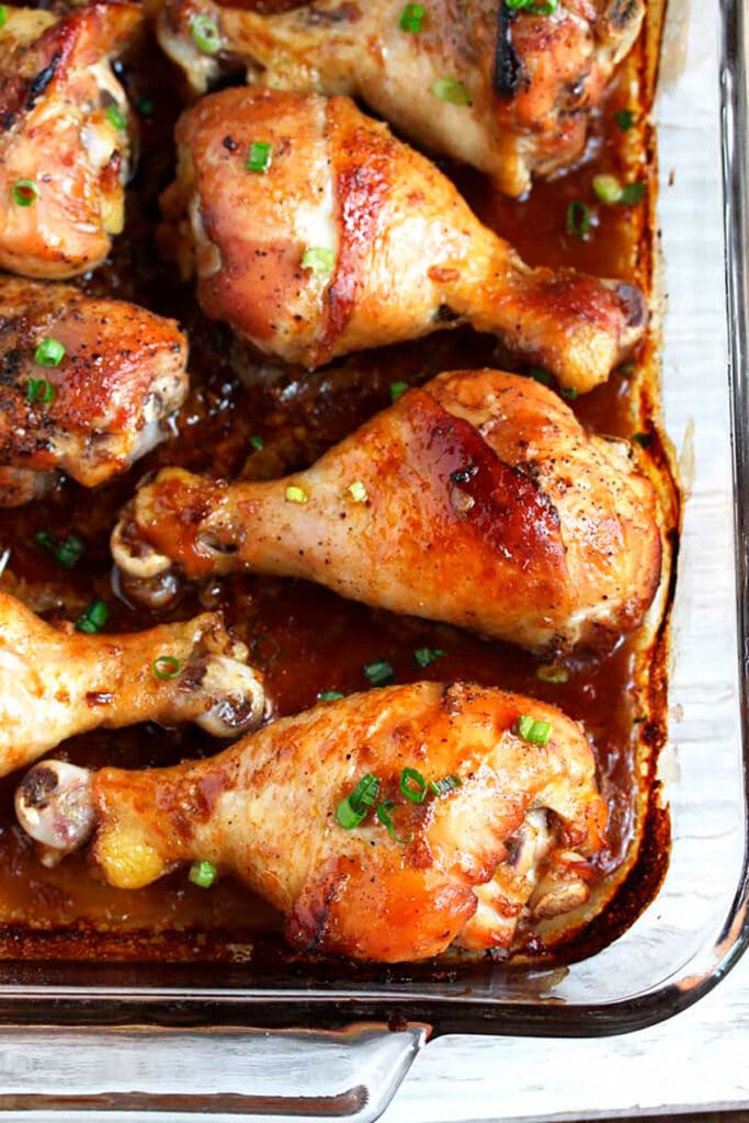 A glass baking pan filled with off the oven chicken legs in a honey say sauce
