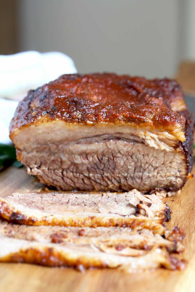 A piece of instant pot BBQ brisket getting sliced on a cutting board.