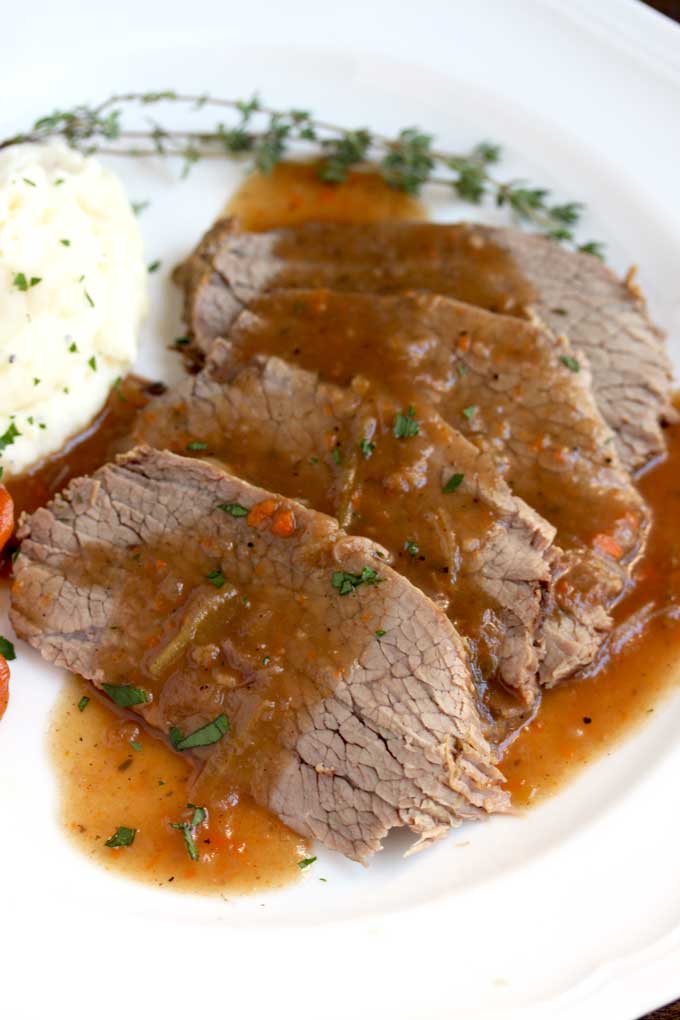 Close up view of sauerbraten slices on a white plate