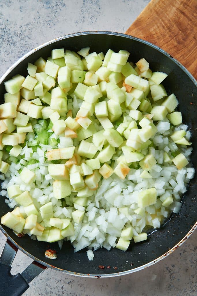 Diced onion, apples and celery in a skillet