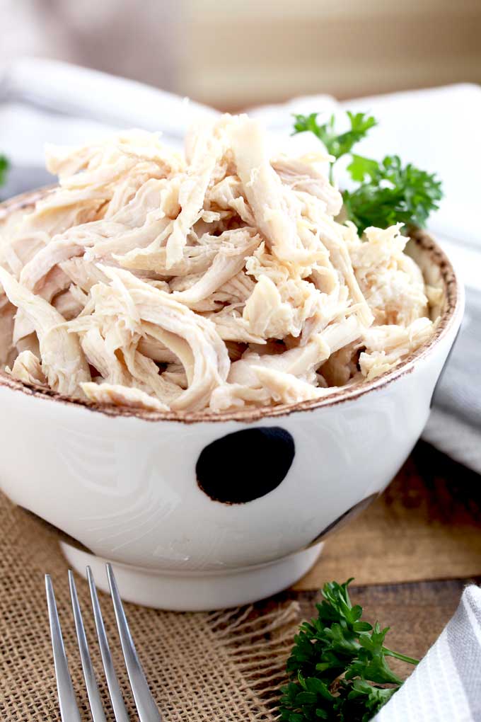 A bowl filled with shredded  chicken breasts cooked in the instant pot.