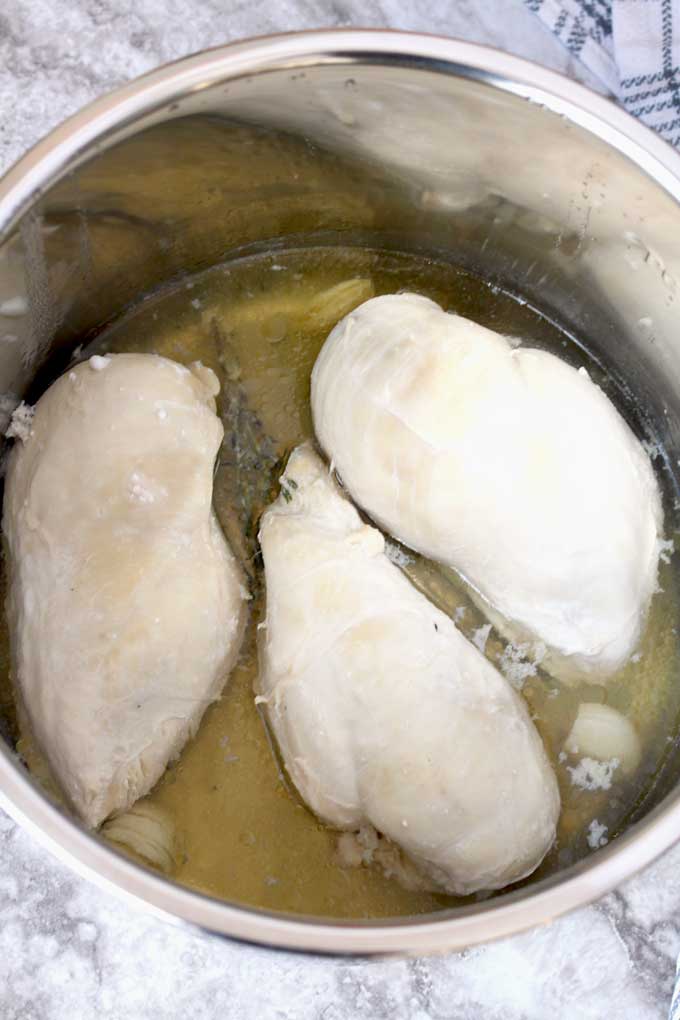 Cooked chicken breasts and broth inside the instant pot