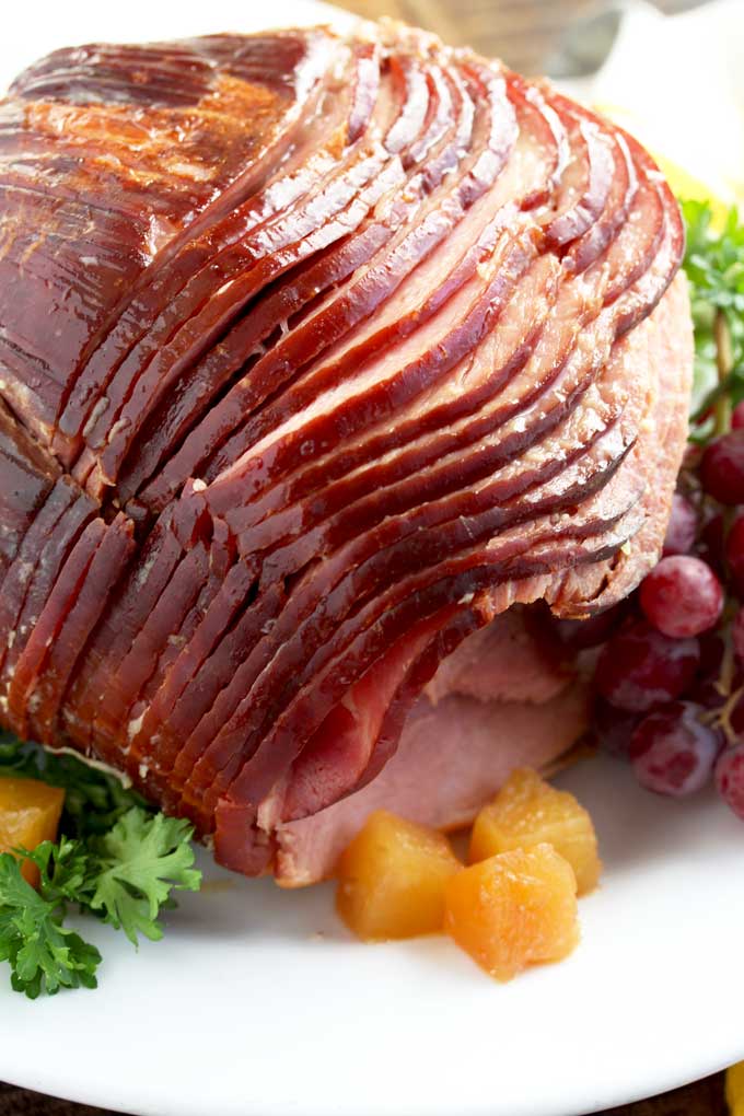 Sliced Spiral Slow Cooker Ham on a white platter.