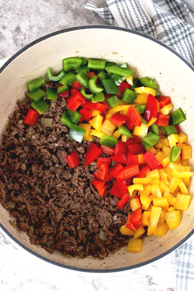 Browned ground beef, sauteed onions and garlic and chopped green, yellow and red bell peppers in a Dutch oven.