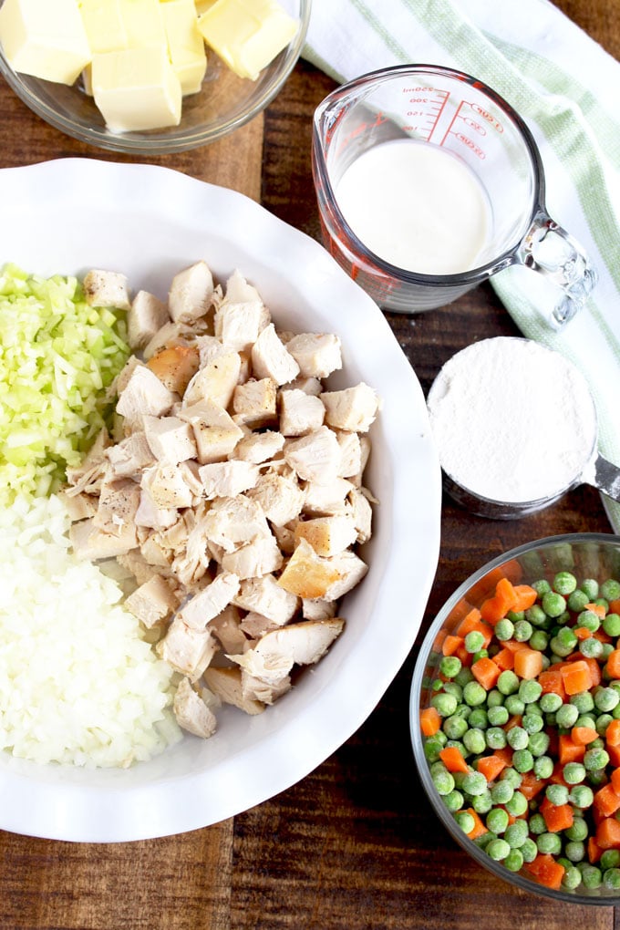 Ingredients to make Turkey Pot Pie set on a wooden surface.