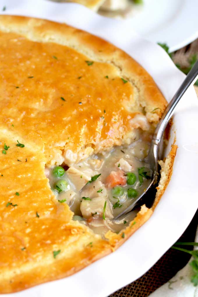 Turkey pot pie getting scooped out from a round baking pie dish.