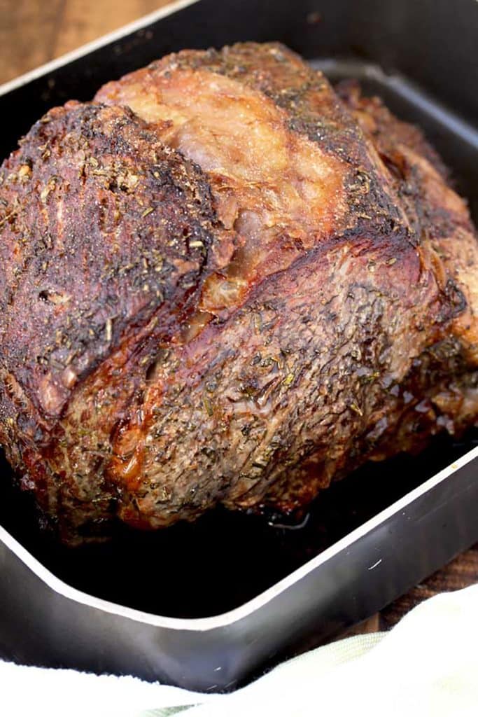Roasted and golden brown Prime Rib Roast in a roasting pan.