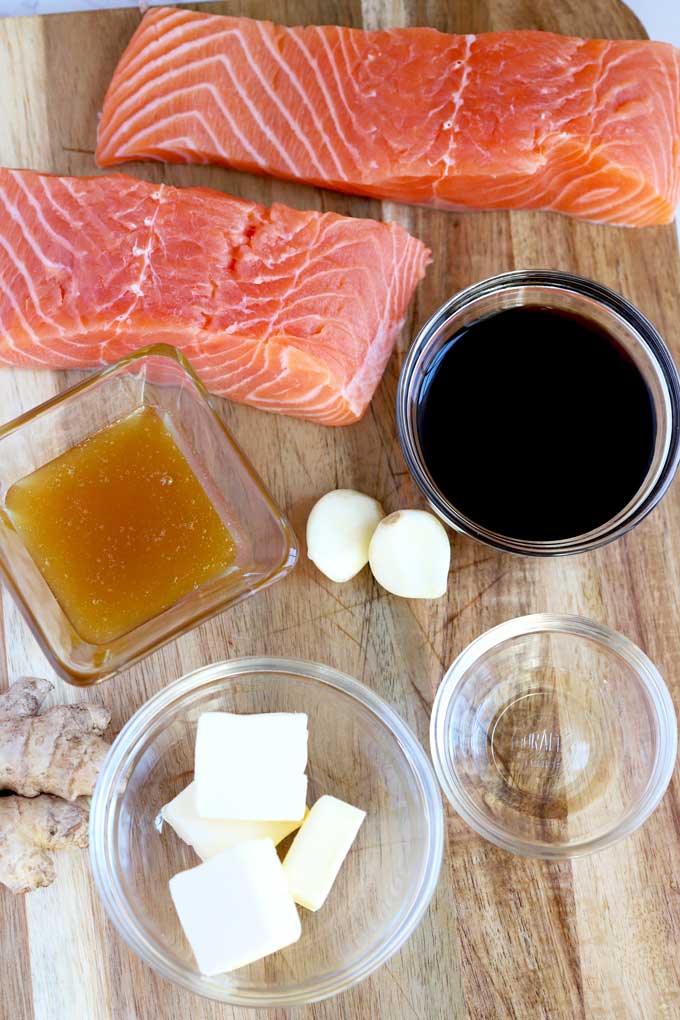 Ingredients to make Oven Baked Salmon with Honey Ginger Glade on a wooden board.