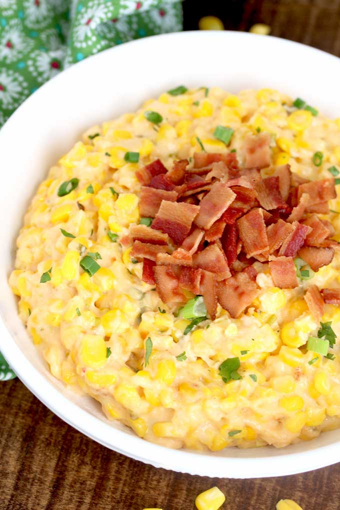 Corn Dip topped with crispy bacon served in a white bowl.