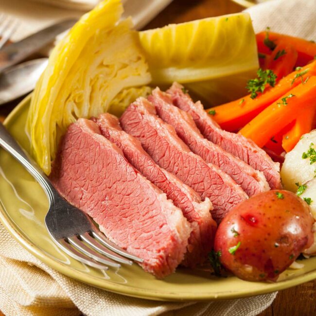 Slices of corned beef served with cabbage, carrots and potatoes.