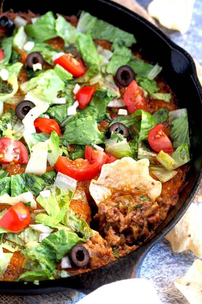 Close up of a chip scooping taco dip