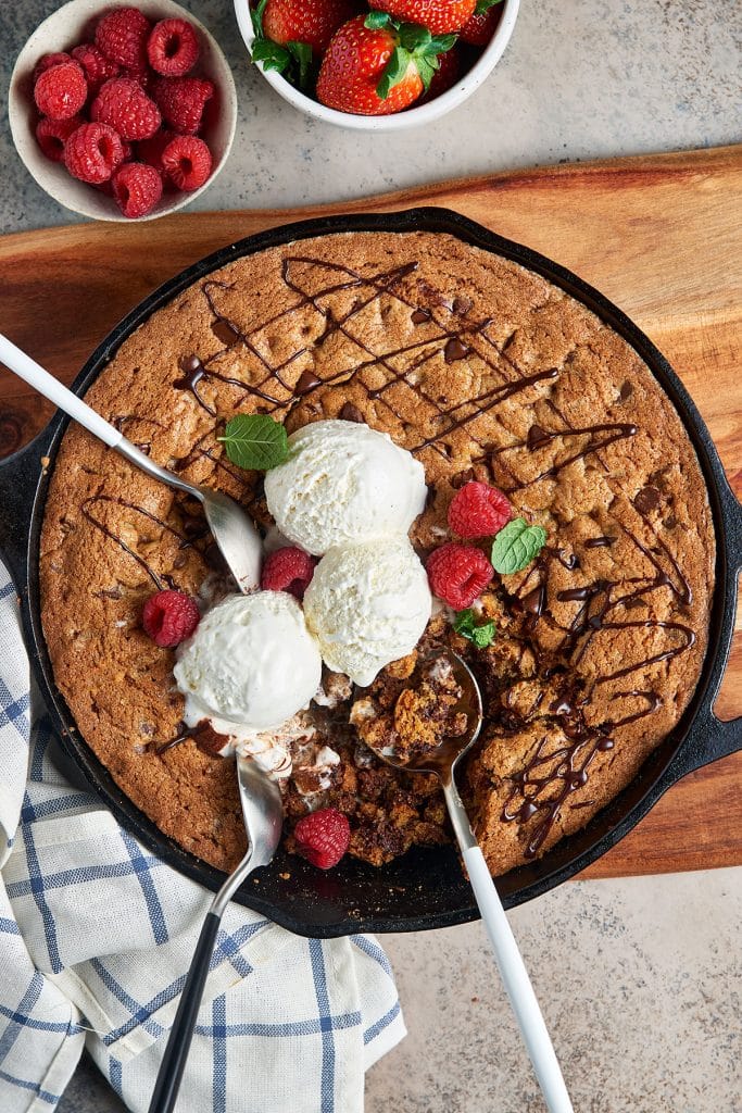 Skillet Cookie topped with ice cream spooned from the skillet.