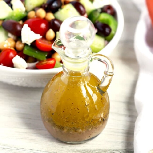 Greek Vinaigrette next to a bowl filled with Greek Salad