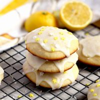 A stack of lemon ricotta cookies topped with lemon glaze and sprinkles.