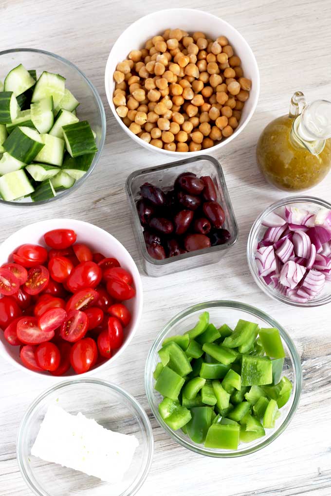 Bowls filled with the ingredients to make this easy Mediterranean salad