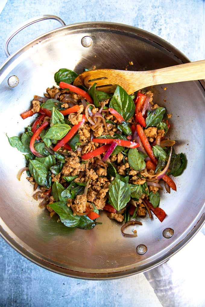 Thai Chicken Basil stir fried in a wok.