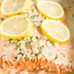 Pin image showing flaky baked salmon topped with lemon