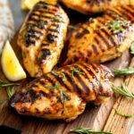 Grilled chicken Breast - lemon Blossoms: Grilled chicken breast on a wooden board.