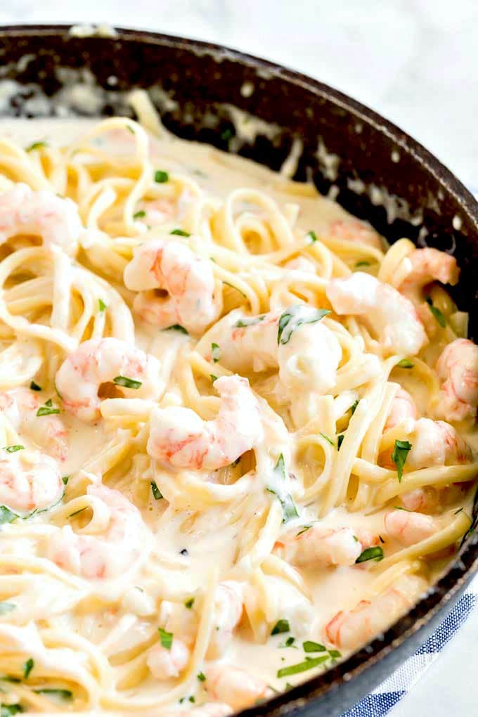 Pasta tossed with creamy garlic Parmesan sauce and shrimp in a skillet