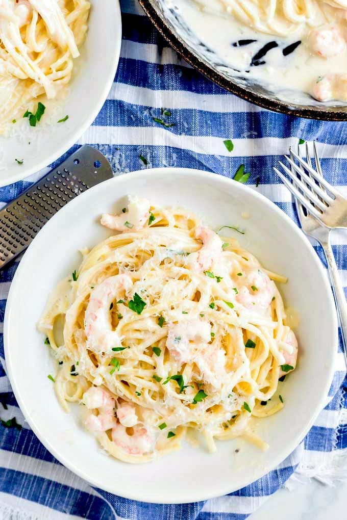 Bowl of parmesan pasta with shrimp in a white bowl.