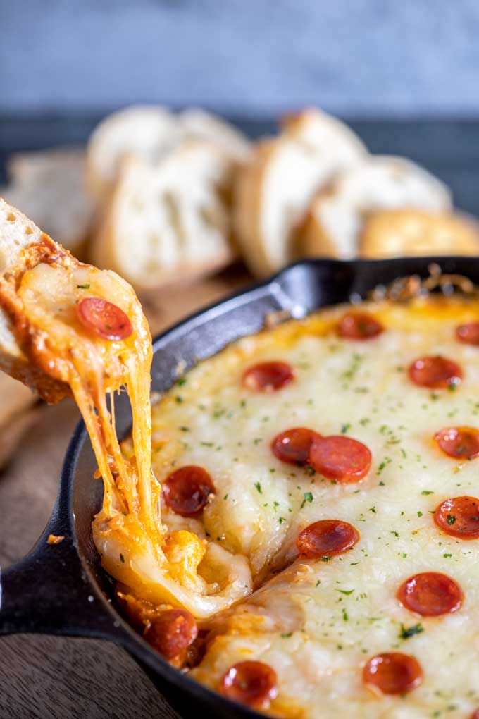 Cheesy dip lifted with a piece of bread