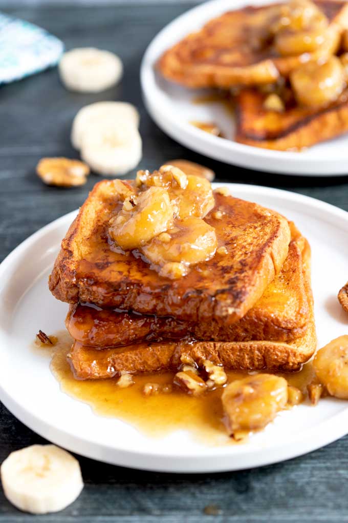 Brioche French toast with banana topping on a white plate