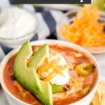 Pin Image of a bowl of chicken tortilla soup with toppings