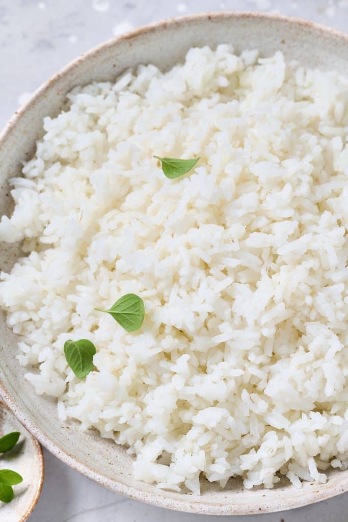 Close up photo showing a bowl filled with fluffy white rice.