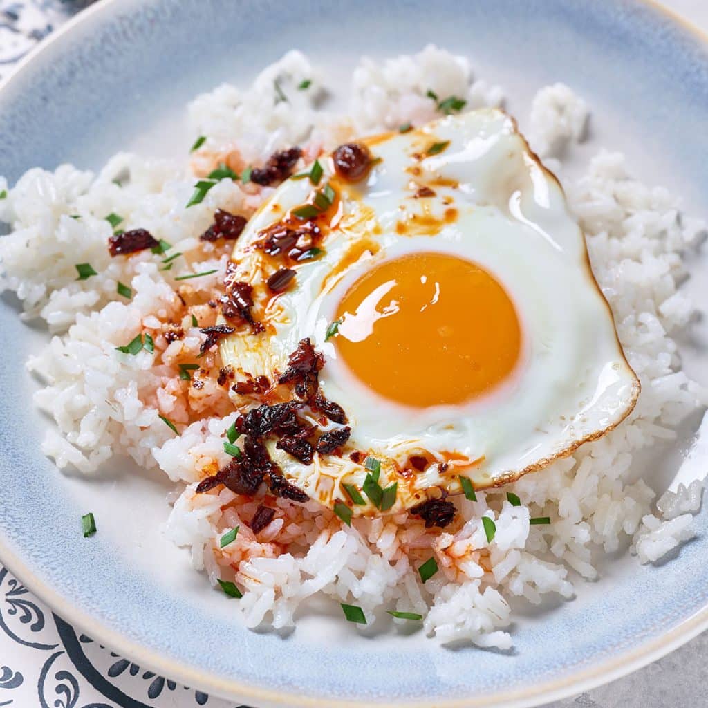 Fluffy rice topped with an over easy egg, scallions and chili sauce
