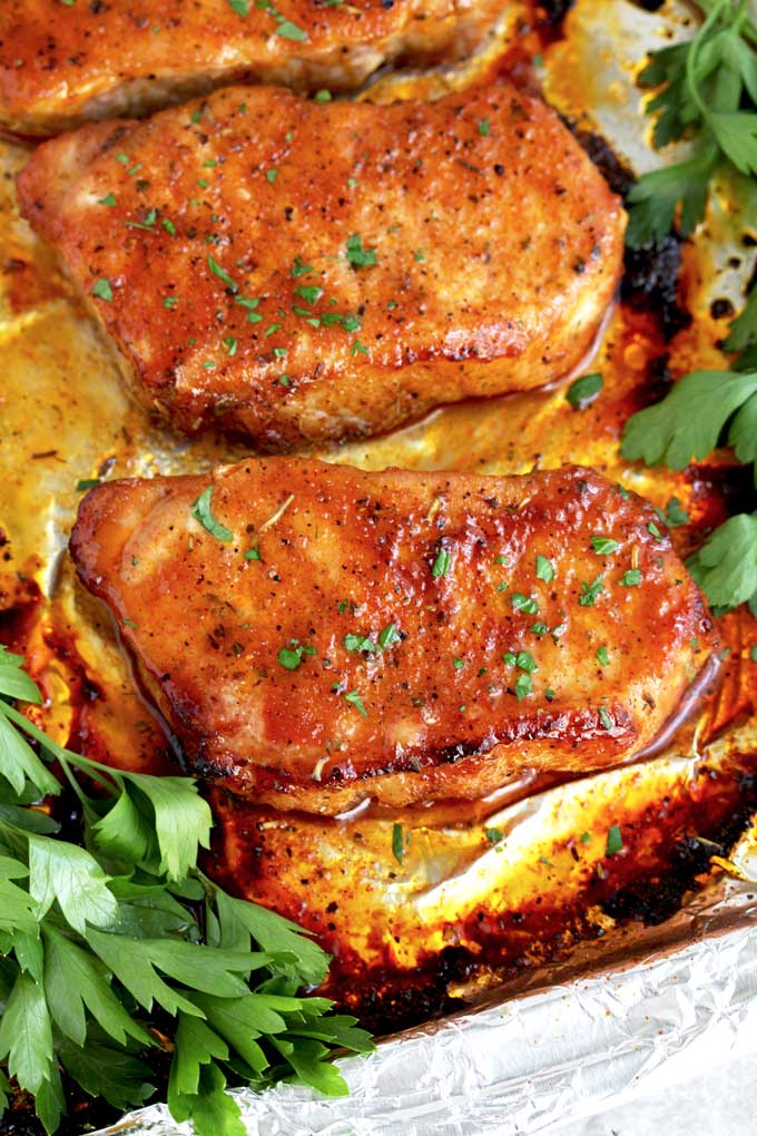 Golden brown juicy pork chops on a sheet pan.