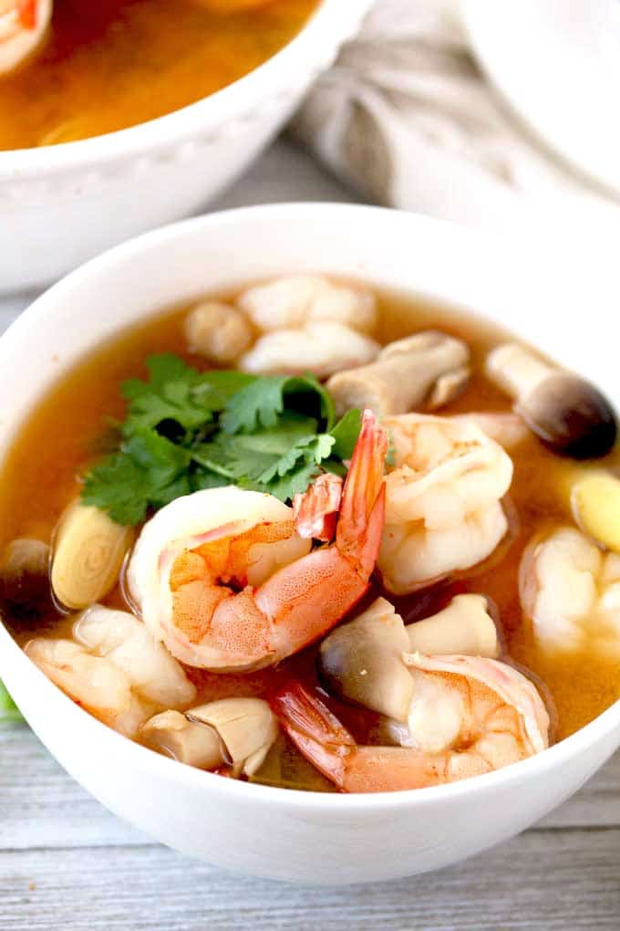 Close up photo of a bowl of Tom Yum Goon in a white bowl
