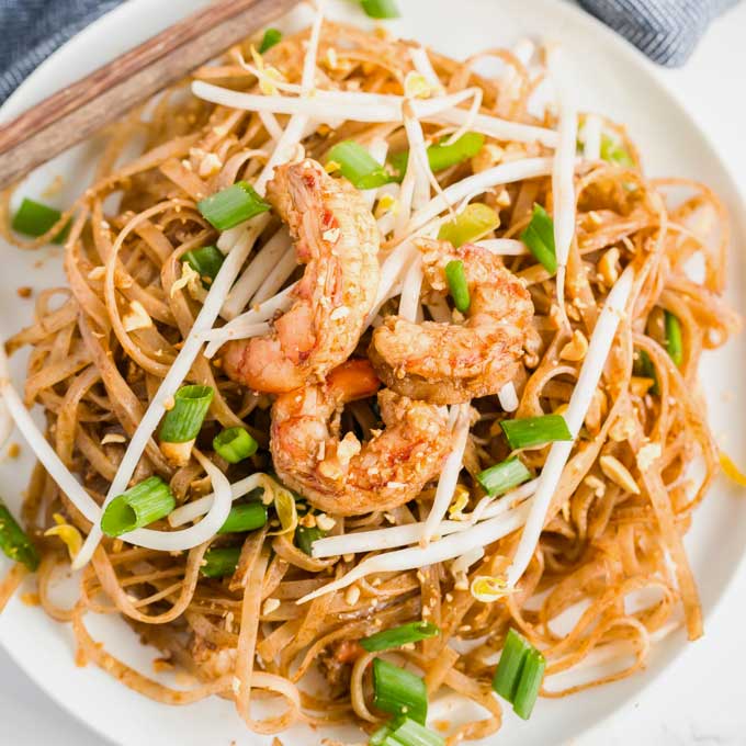 top view of a White plate filled with Pad Thai.