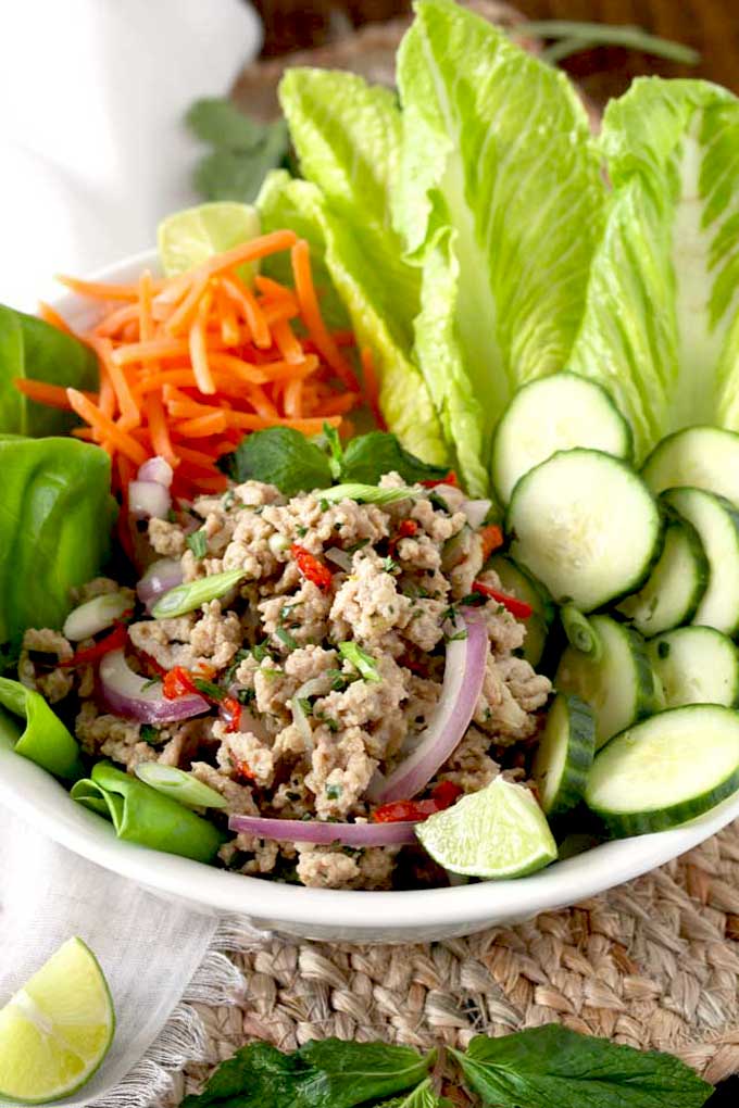 Thai Larb salad served with vegetables in a white bowl.