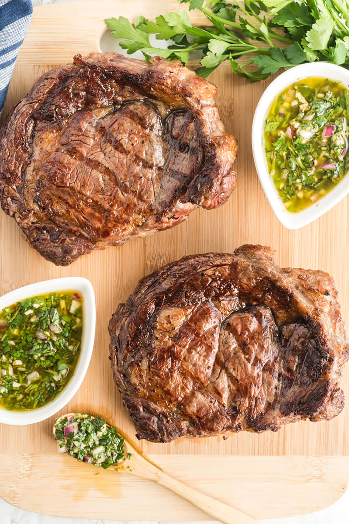 Perfectly grilled ribeye steaks on a cutting board.