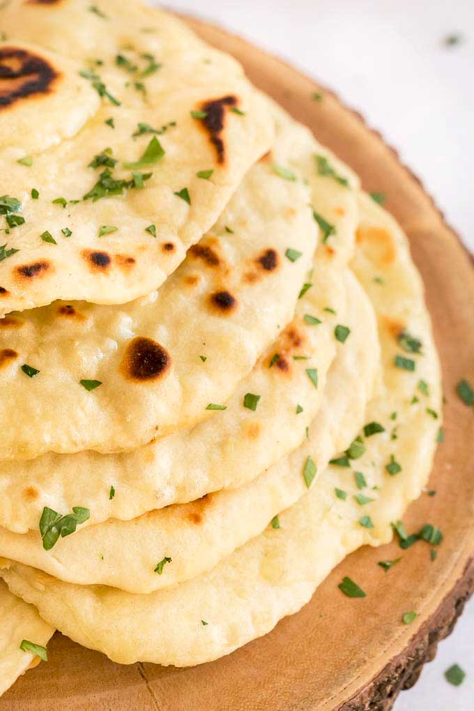 A stack of flatbread on a wooden surface.