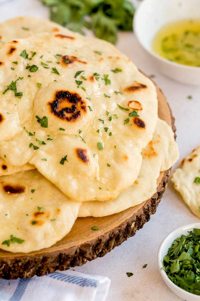 Flatbreads brushed with butter on a wooden block