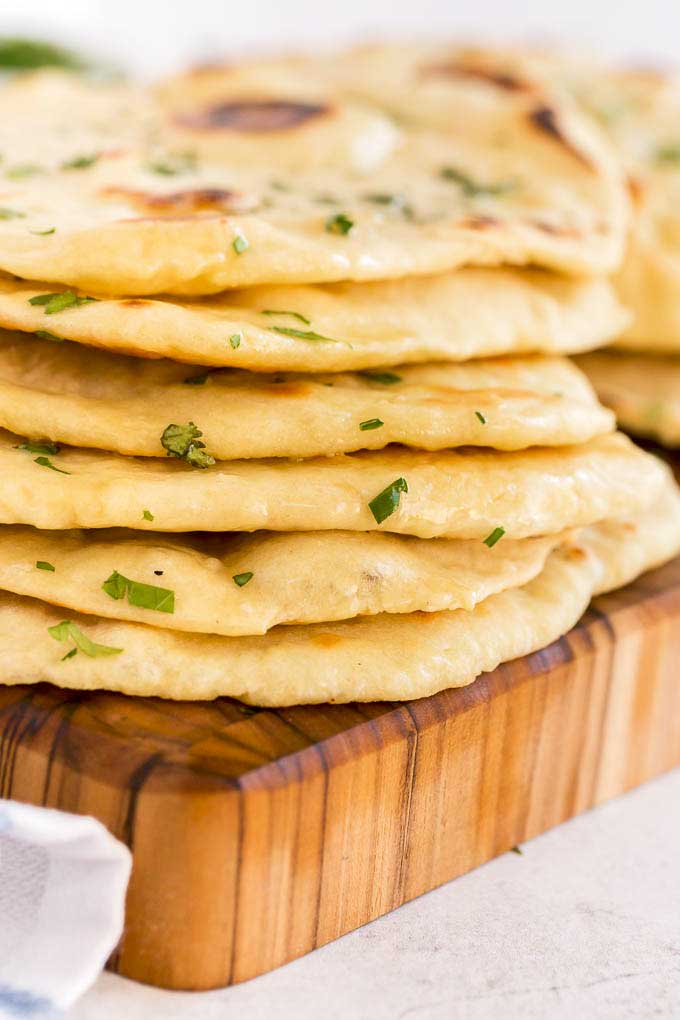A stack of flatbread on a wooden board