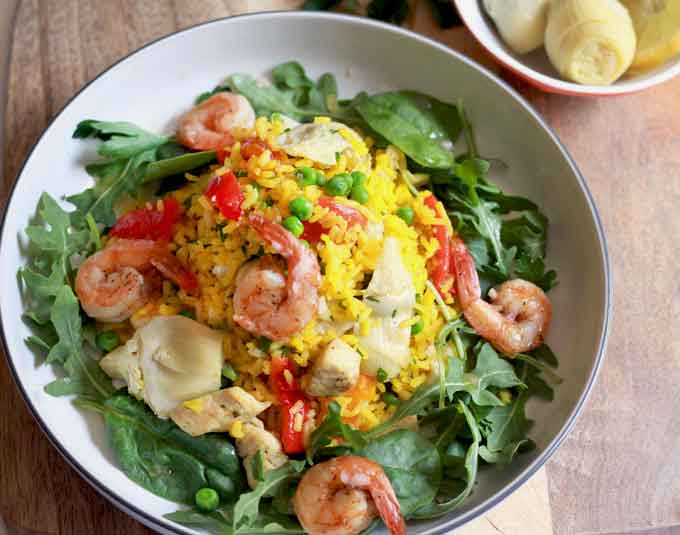 Top view of a bowl filled with shrimp and chicken paella salad.