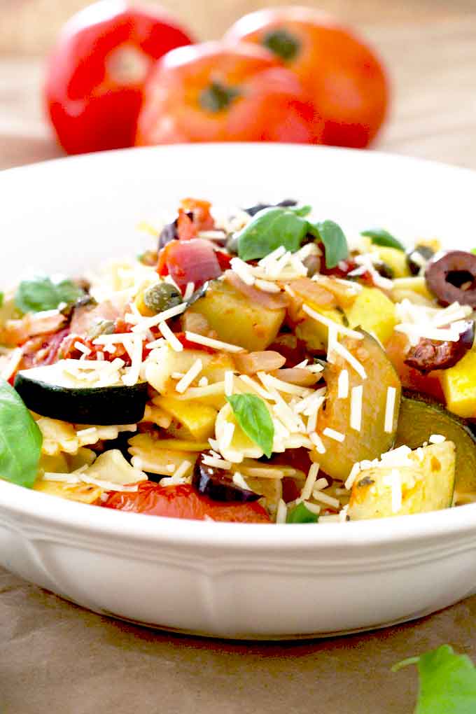 Summer vegetables pasta on a white bowl.