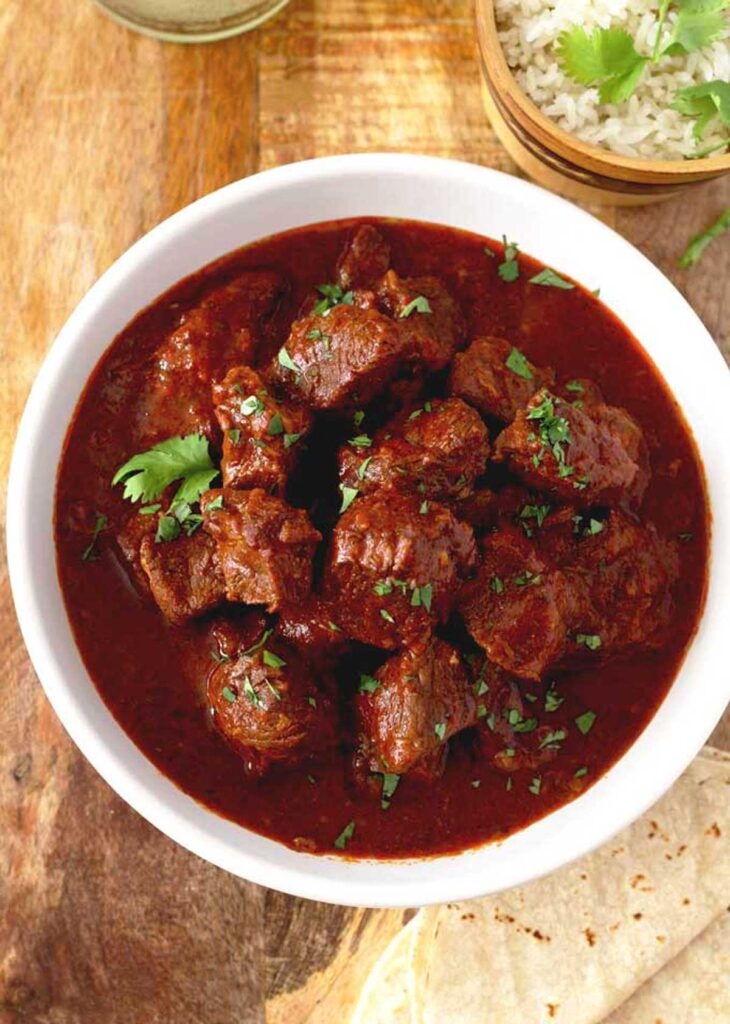 Mexican beef stew with red colorado sauce on a white bowl