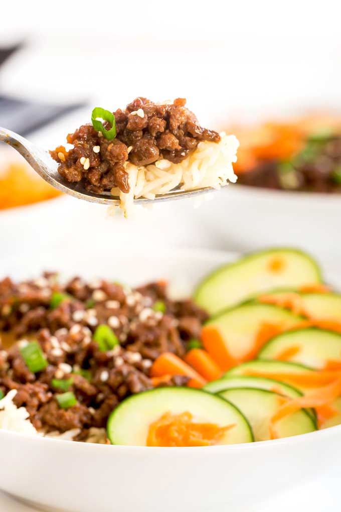 a fork lifting korean ground beef and rice