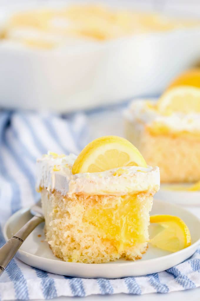 A piece of lemon poke cake on a white plate.