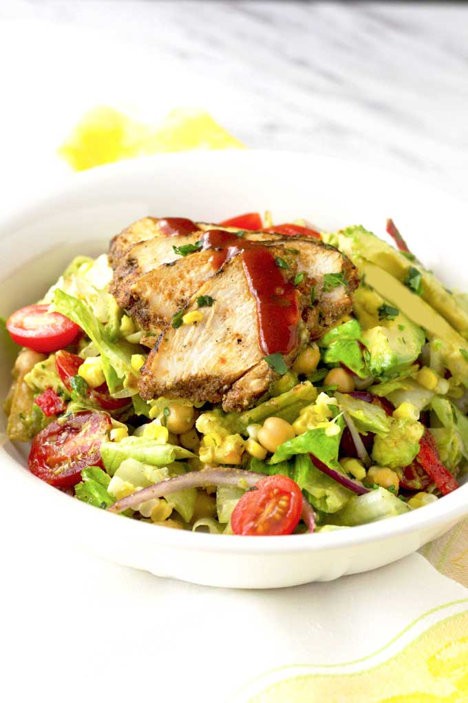 Mexican Chopped Salad topped with BBQ chicken in a white bowl.