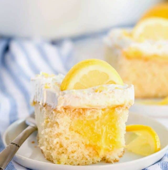 A piece of lemon poke cake on a white plate.