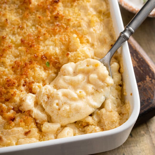 Creamy baked mac and cheese scooped out of a baking pan